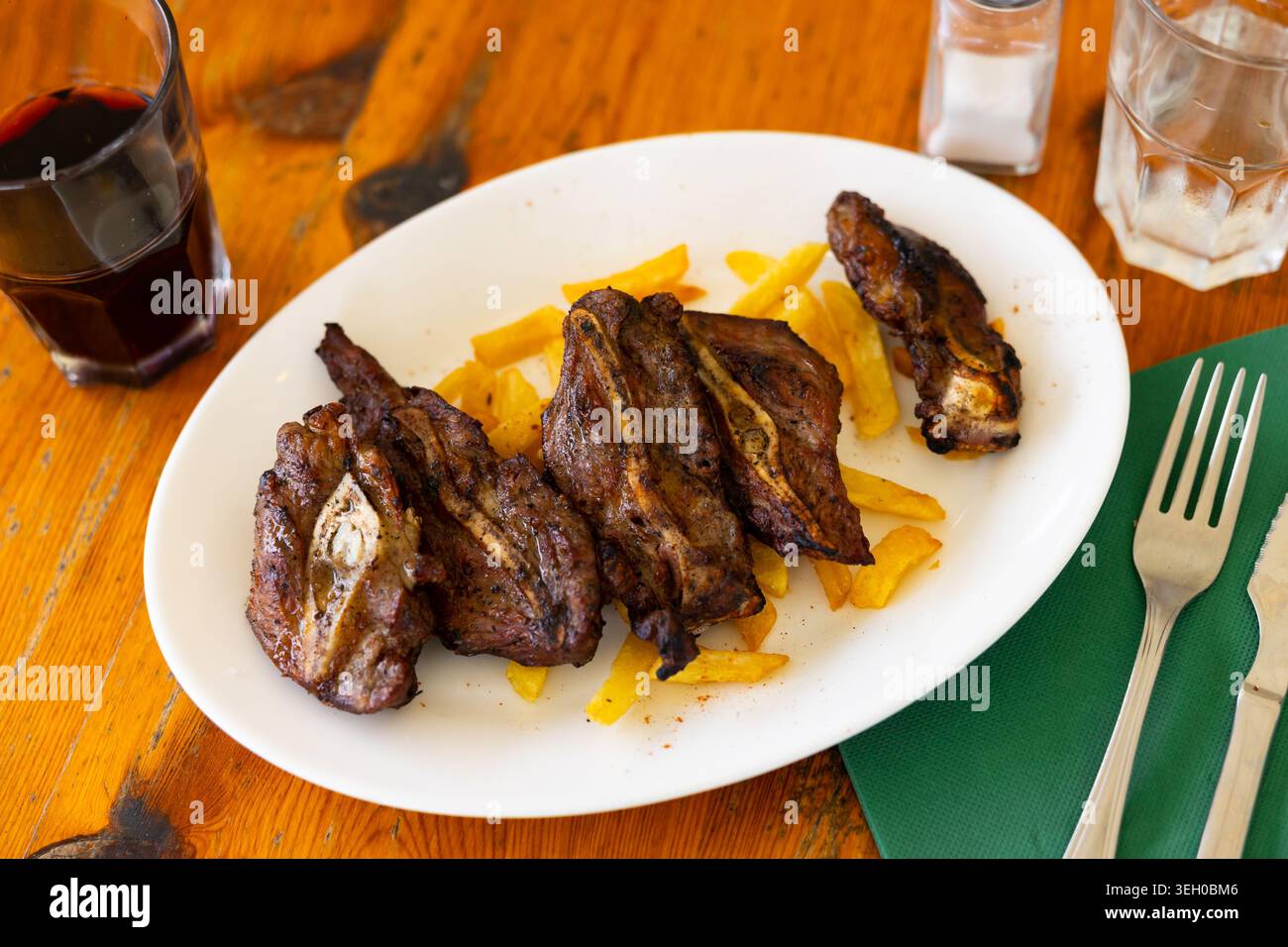 Gebackene Schweinebacke serviert mit Kartoffeln Stockfoto
