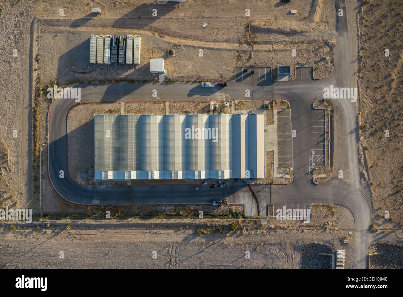 Luftaufnahme eines großen Industriegebäudes mit Welldach, gepflasterten Zufahrtsstraßen und Parkplätzen in der Wüste Enterprise, Nevada, United Stat Stockfoto