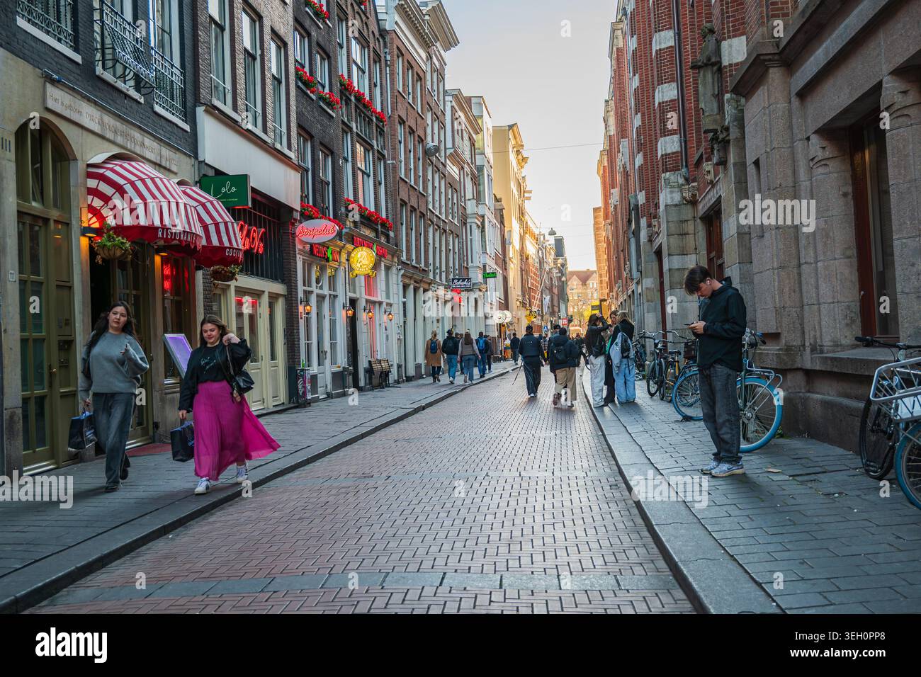 Amsterdam, Niederlande, 22.04.2026 - historische europäische Straße mit Fußgängerzonen, Restaurants und abendlicher Stadtatmosphäre Stockfoto