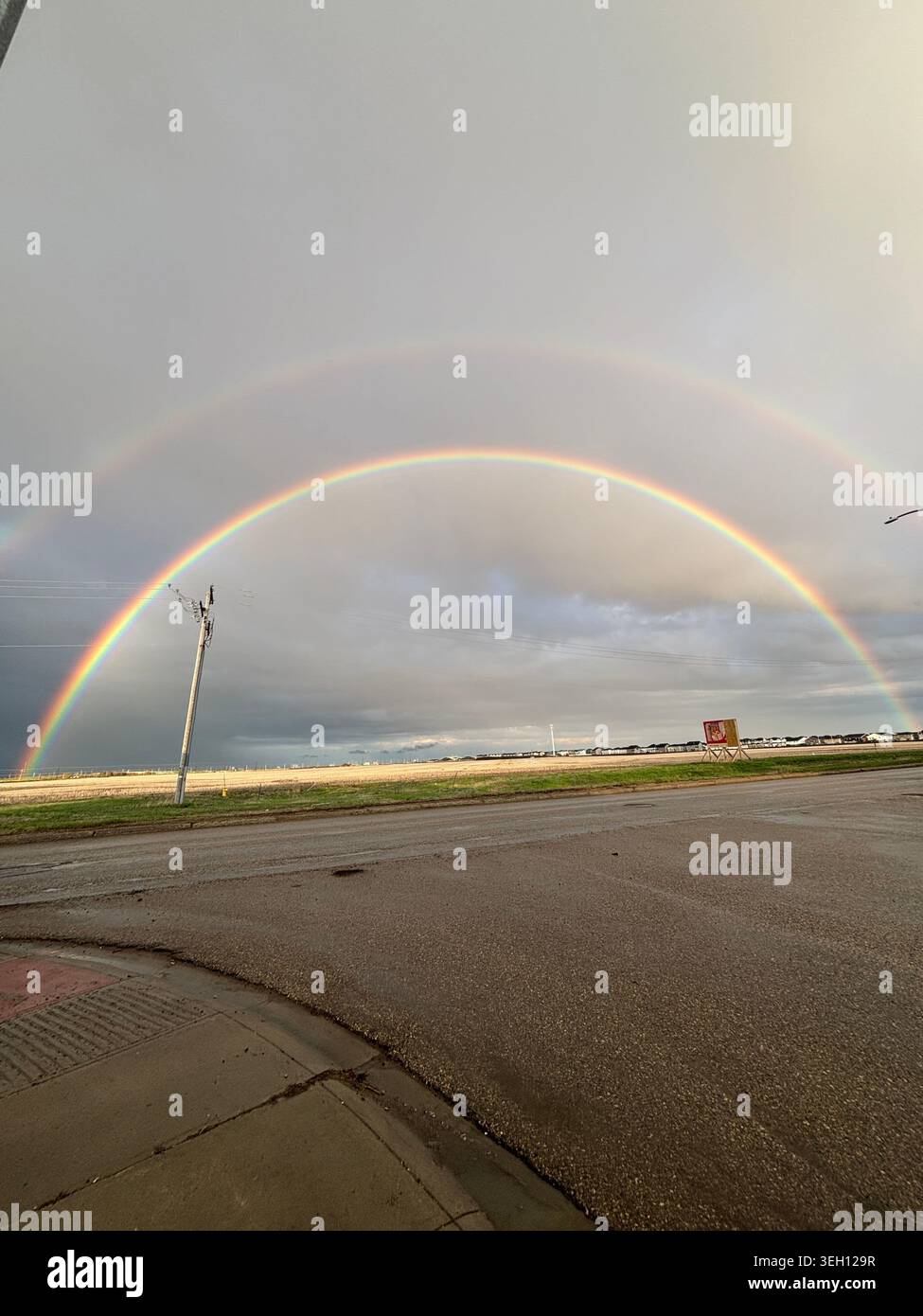 Double Rainbow Über Vorstadthäusern Stockfoto