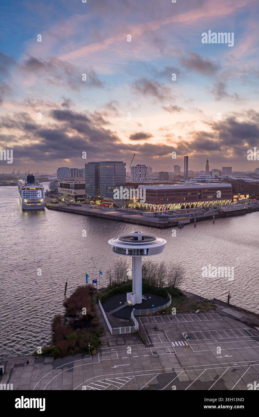 Aus der Vogelperspektive des Leuchtturms Zero mit einem Kreuzfahrtschiff im Hafen und der Skyline der Stadt unter einem farbenfrohen Sonnenuntergang Hamburg, Hamburg, Deutschland. Stockfoto