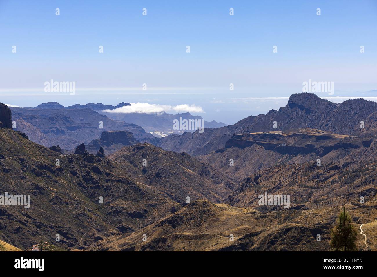Ausgedehnte vulkanische Berglandschaft mit tiefen Tälern und entfernten Wolkenschichten in der Region Roque Nublo auf Gran Canaria. Stockfoto