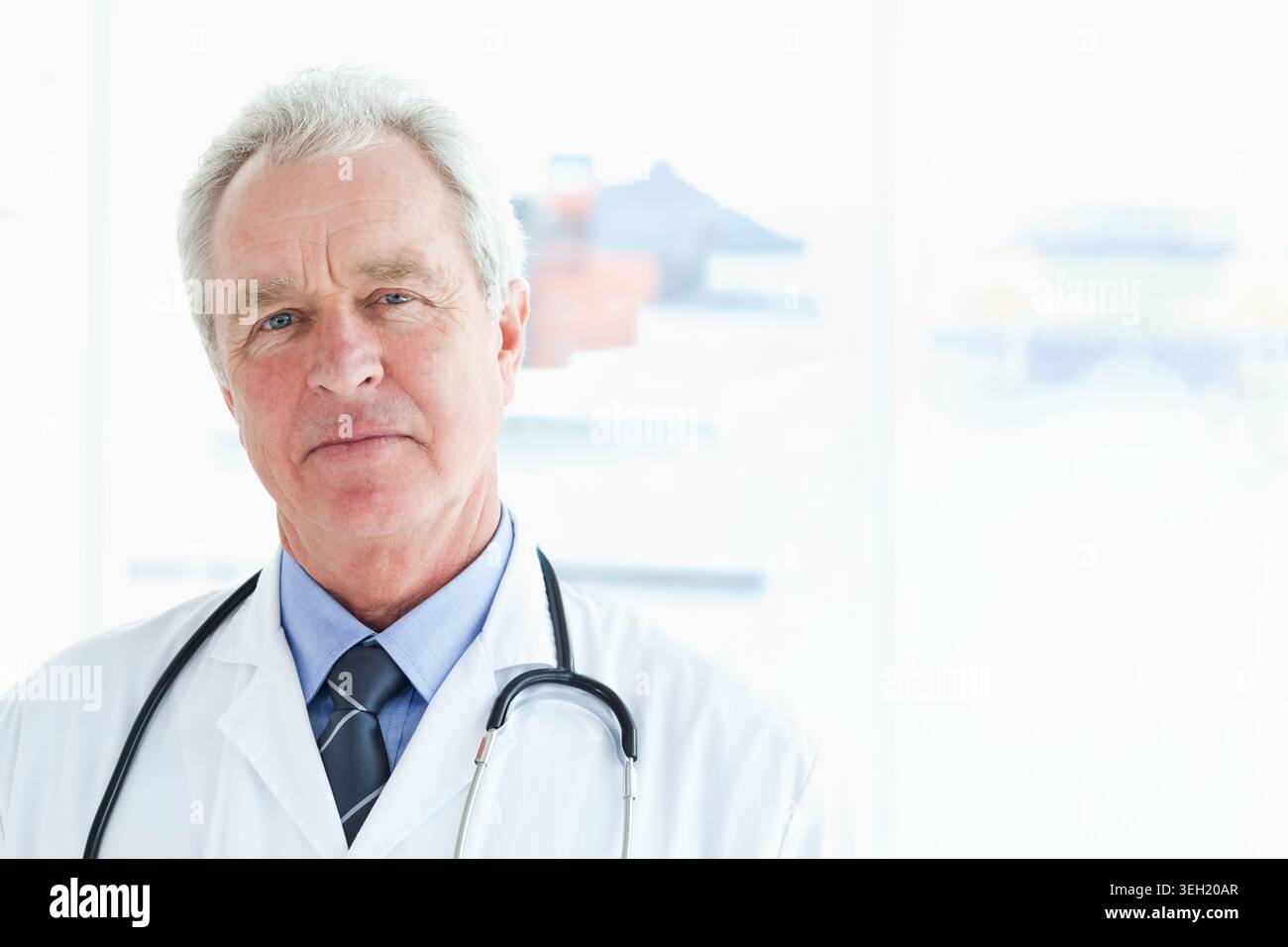Oberarzt in Klinik mit weißem Labormantel und Stethoskop Stockfoto