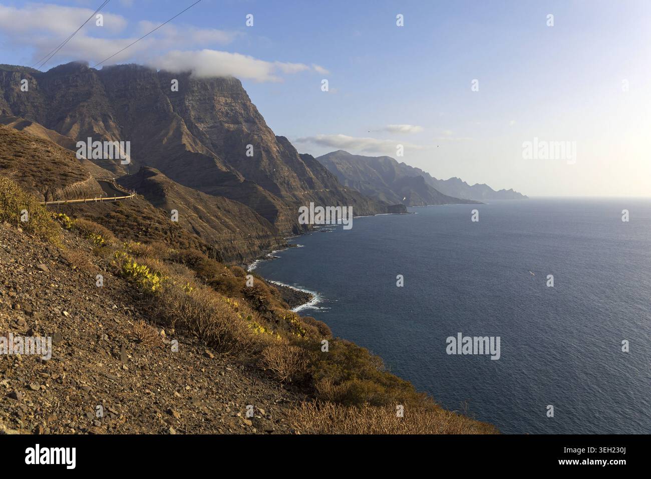 Sonnendurchflutete vulkanische Klippen und die Atlantikküste in der Nähe von Agaete an der Nordwestküste von Gran Canaria, Kanarischen Inseln, Spanien. Stockfoto
