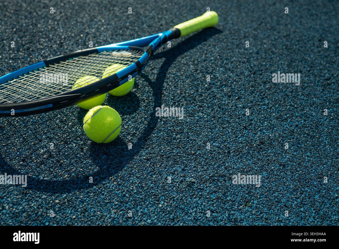 Tennisball auf Tennisschläger auf dem Sportplatz im Freien bei warmem Sonnenlicht. Minimales aktives Lifestyle-Konzept mit Kopierraum und geringer Tiefe von f Stockfoto