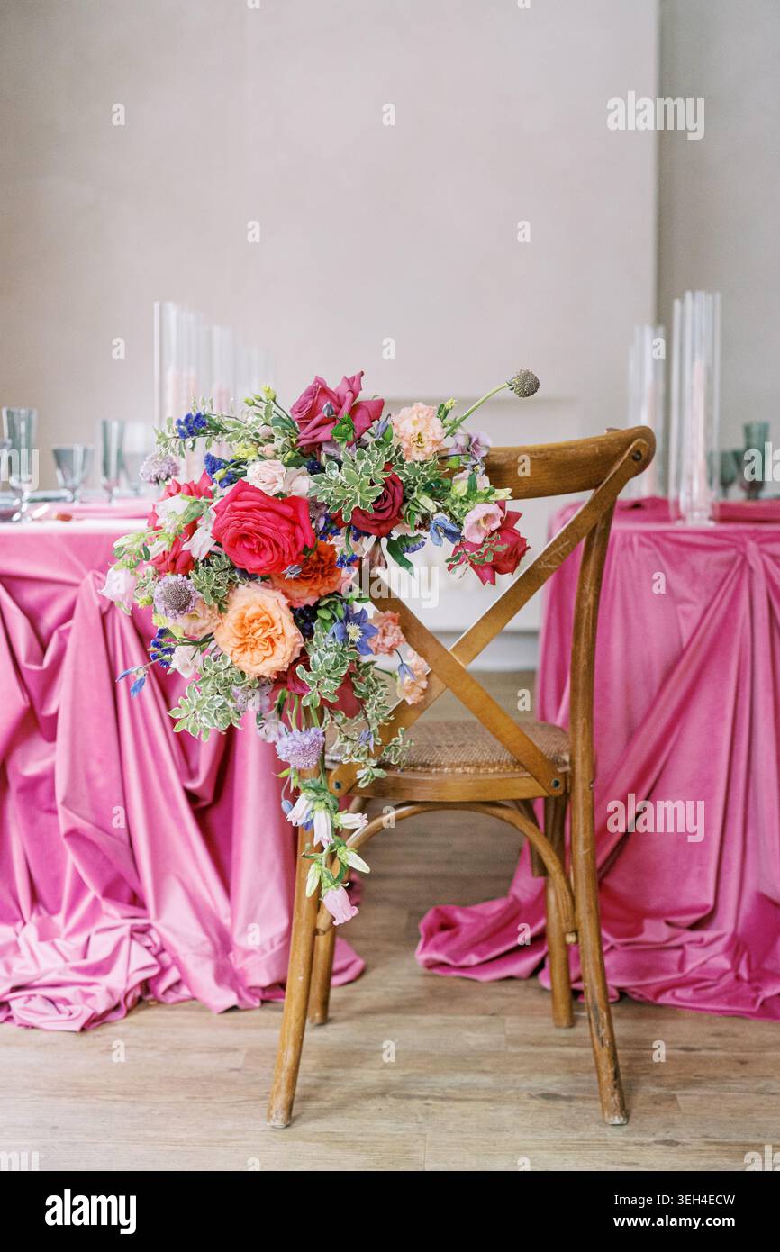 Elegante Einrichtung für Veranstaltungen mit Blumenarrangements und rosafarbener Tischdecke Stockfoto