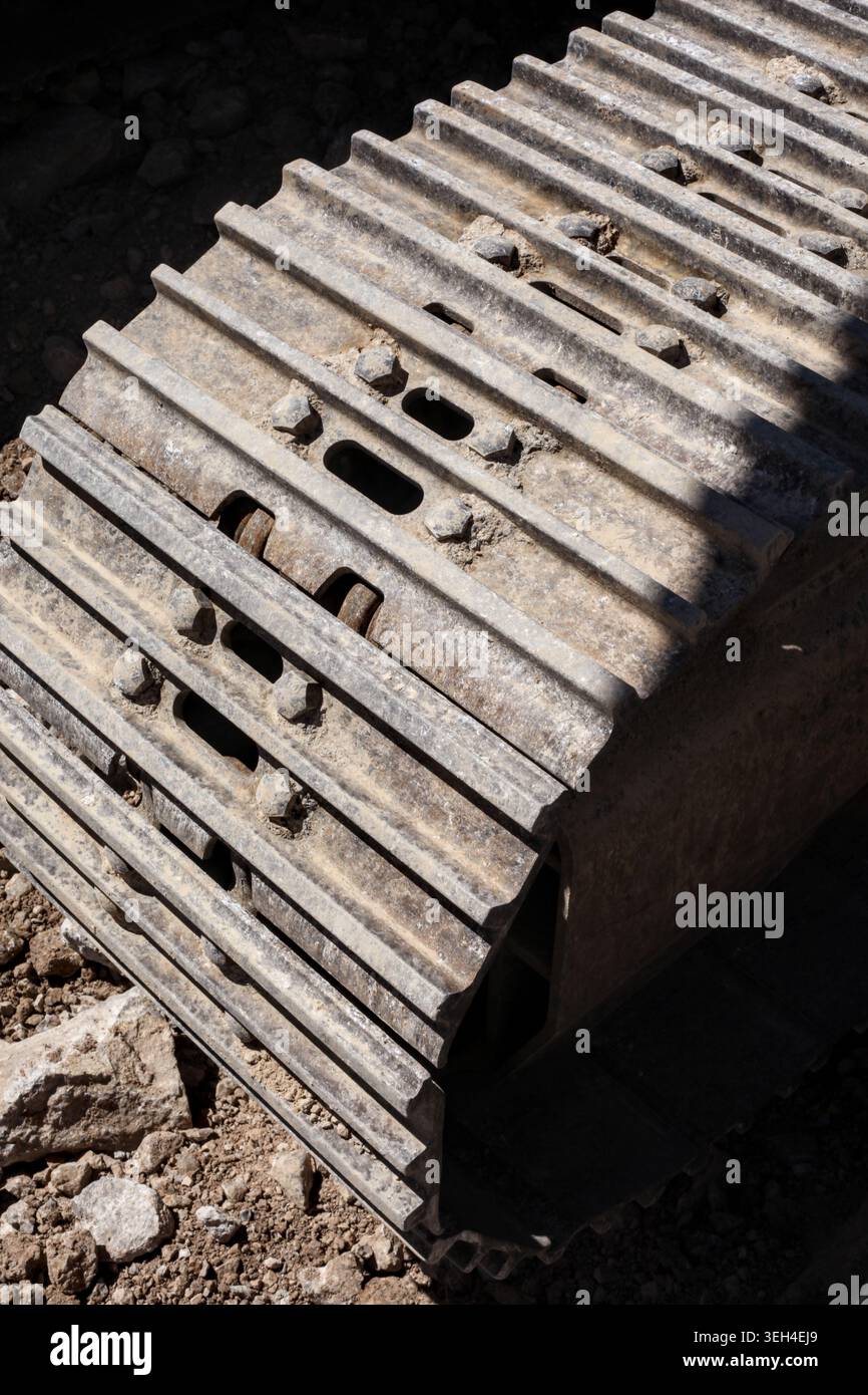 Hochwinkelansicht eines schweren, schmutzigen Stahllaufkastens und Stegs auf einem Industriebagger. Stockfoto