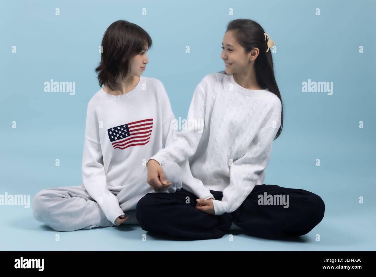 Zwei junge Frauen sitzen auf dem Boden Stockfoto