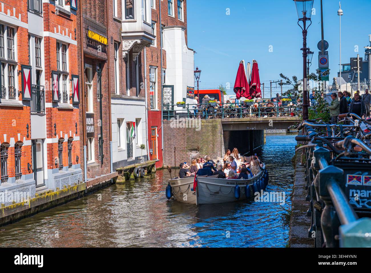 Amsterdam, Niederlande, 22.04.2026 - Touristenboot, das durch den engen Amsterdamer Kanal fährt Stockfoto