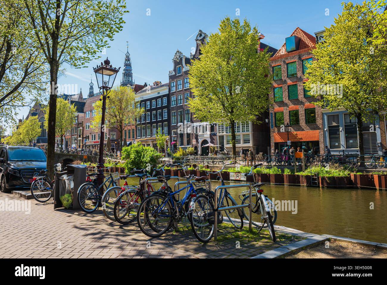 Amsterdam, Niederlande, 22.04.2026 - Fahrräder parken am sonnigen Frühlingstag entlang des Amsterdamer Kanals Stockfoto