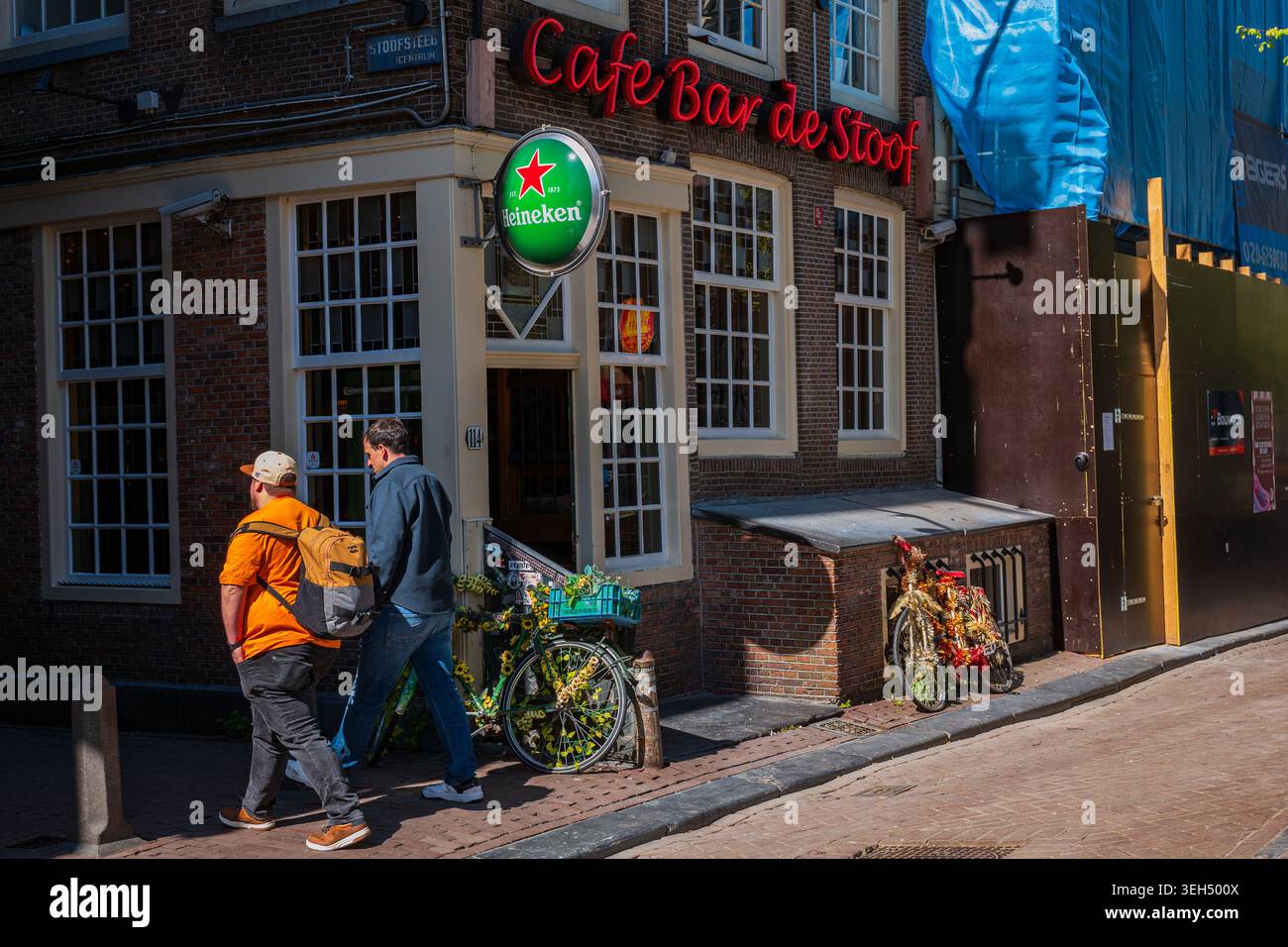 Amsterdam, Niederlande, 22.04.2026 - Menschen gehen an der traditionellen Amsterdamer Café-Bar auf der sonnigen Straße vorbei Stockfoto