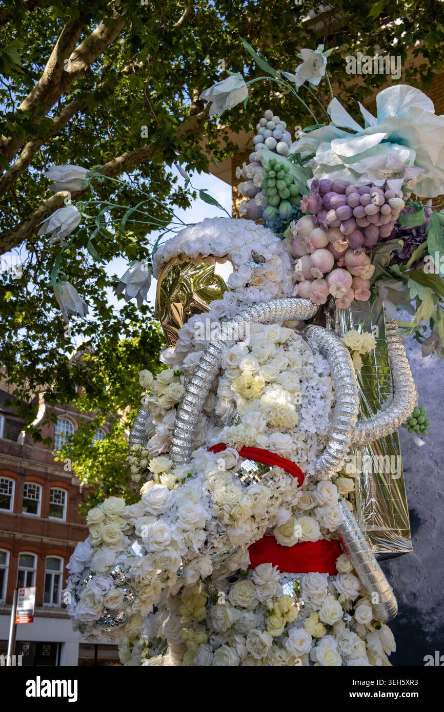 Blumenplastik des Astronauten auf der Chelsea Flower Show 2026 in London. Mit einem Raumanzug in weißer Rosette, einem goldenen Visier und Pastellblüten neben einer Mondkugel. Stockfoto