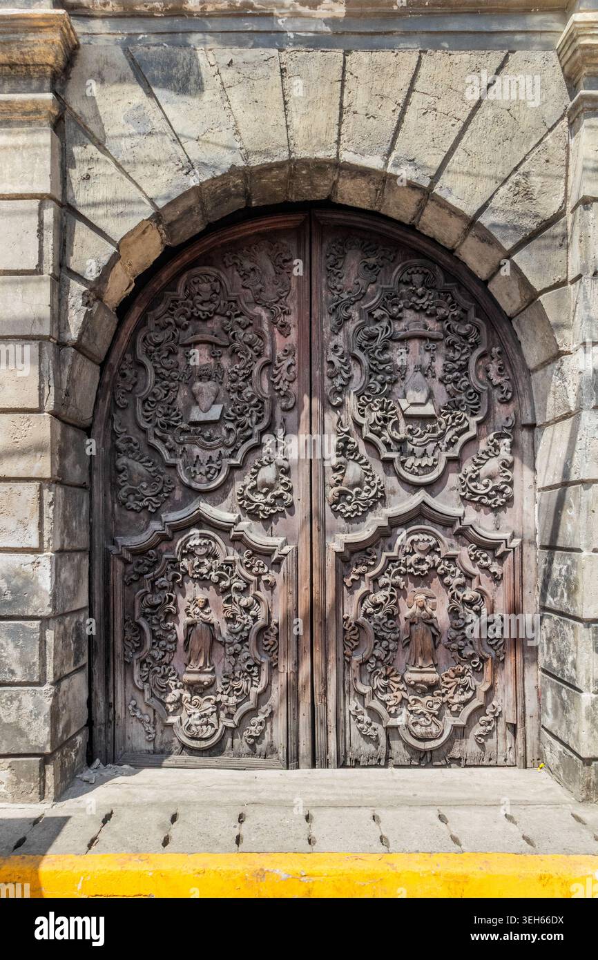 Kunstvoll geschnitzte antike Tür der Kirche San Agustin in Intramuros, Manila, Philippinen, die zum UNESCO-Weltkulturerbe gehört Stockfoto