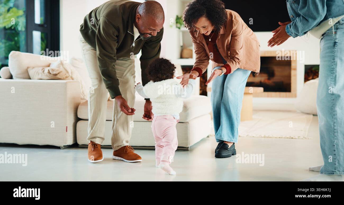 Eltern, Baby und freuen sich auf die ersten Schritte in der Lounge mit Unterstützung, Beifall oder Meilenstein in der Familie zu Hause. Menschen, Mutter und Vater mit Kindern Stockfoto