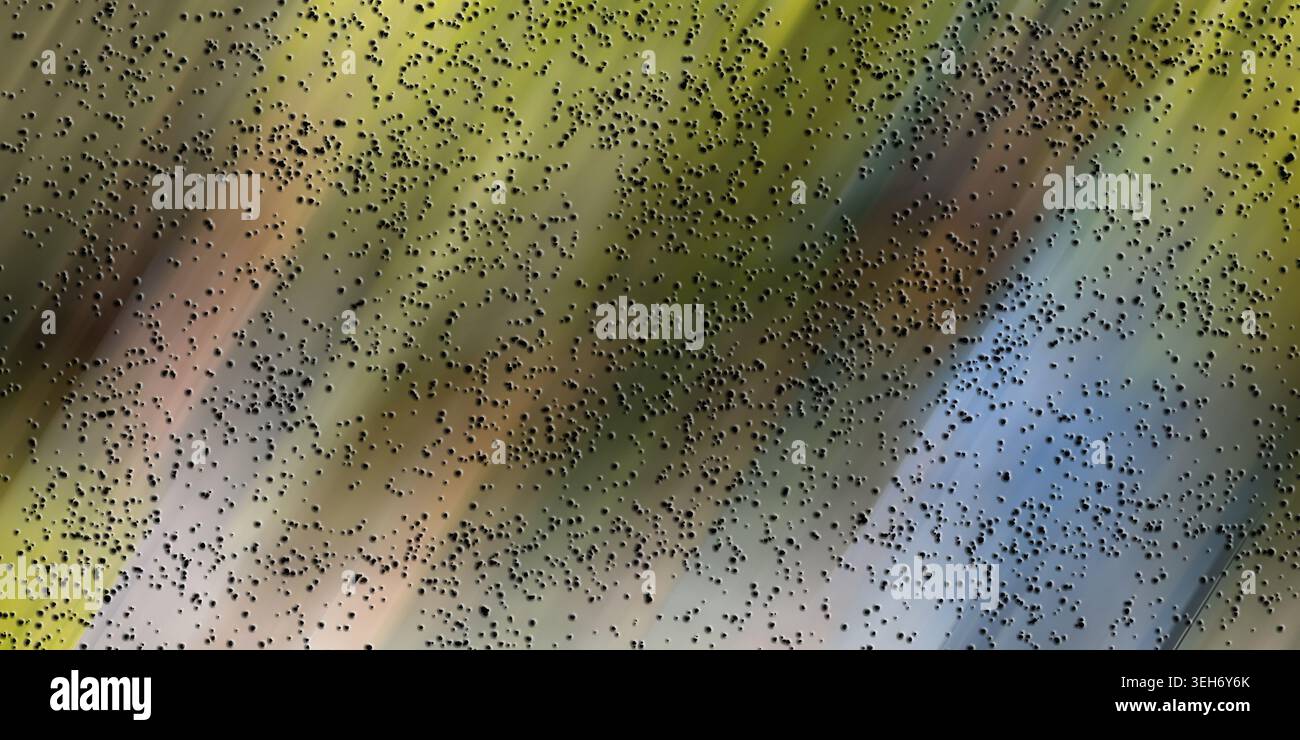 Ein abstrakter digitaler Hintergrund, der gelbe und blaue diagonale Lichtstreifen vermischt, bedeckt von einer feinen Textur aus verstreuten schwarzen Partikeln. Stockfoto