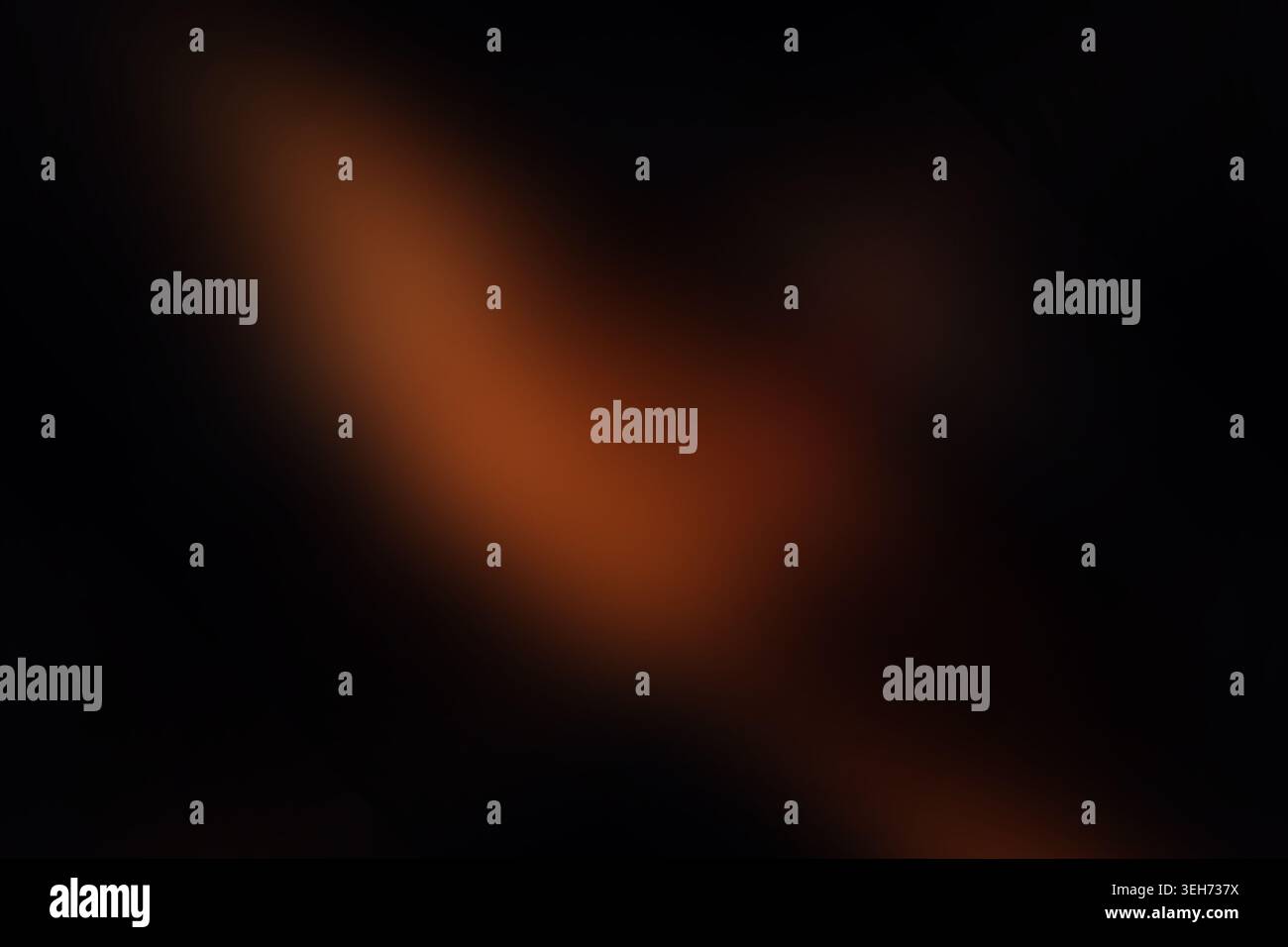 Ein weicher, unscharfer abstrakter Hintergrund mit einem Farbverlauf aus warmem orangefarbenem Licht, das in tiefschwarze Schatten verblasst und einen stimmungsvollen und geheimnisvollen geldautomaten erzeugt Stockfoto