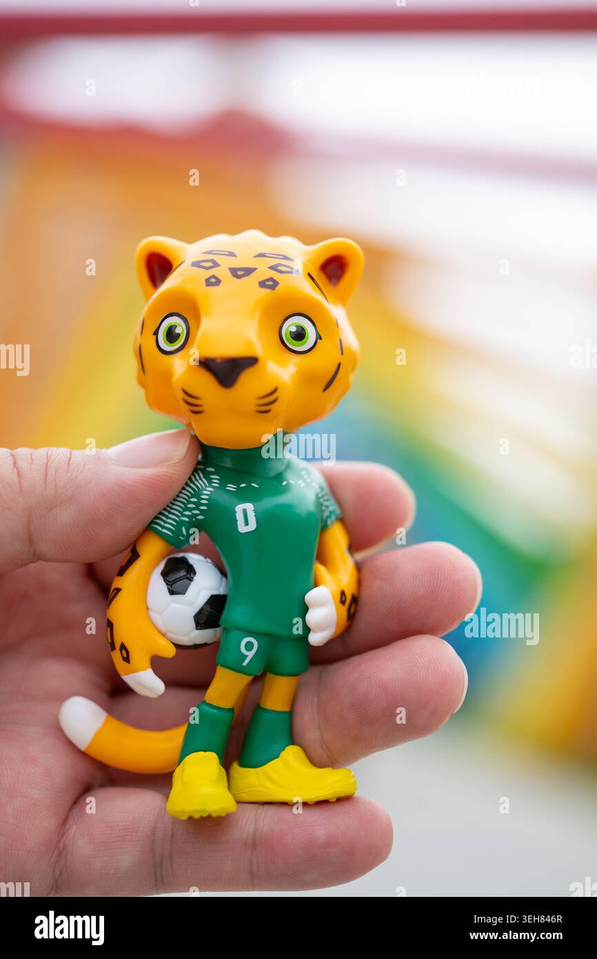 Zhongshan Guangdong China-23. Mai 2026: Hand mit einem Maskottchen Zayu des WM-2026-Logos im Freien in vertikaler Kompositfarbe. Stockfoto