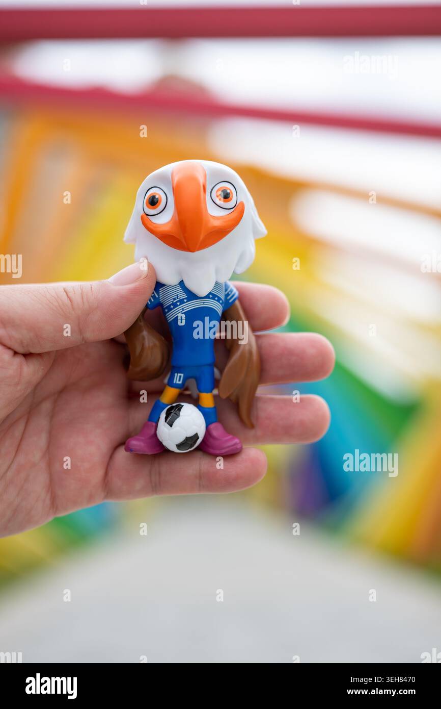 Zhongshan Guangdong China-23. Mai 2026: Hand hält ein Maskottchen Clutch of World Cup 2026 Logo im Freien in vertikaler Kompositon. Stockfoto