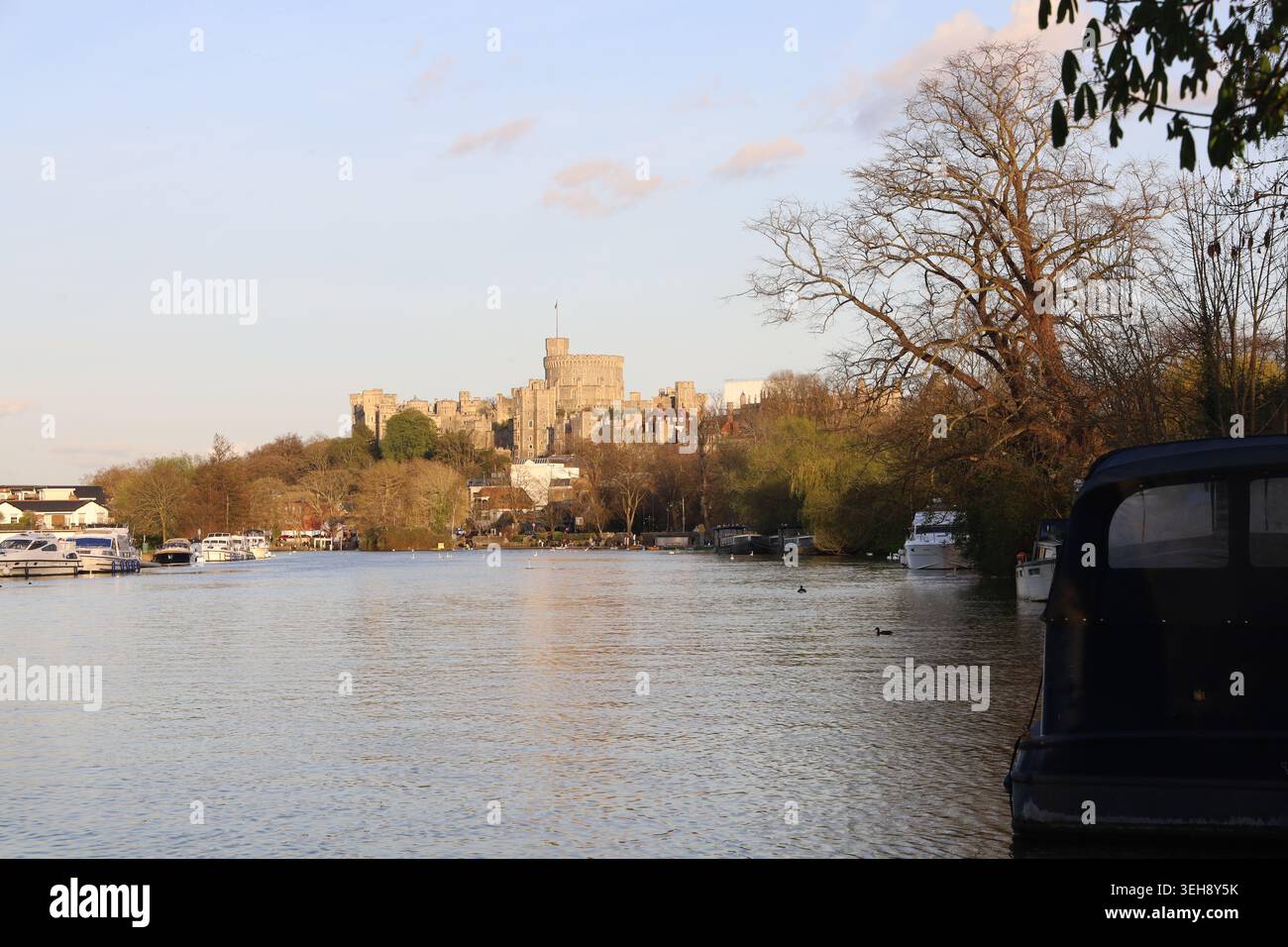 Das Windsor Castle von einer ruhigen Themse mit Booten, Bäumen, ruhigen Gewässern und Schatten aus gesehen, das Vereinigte Königreich. Stockfoto