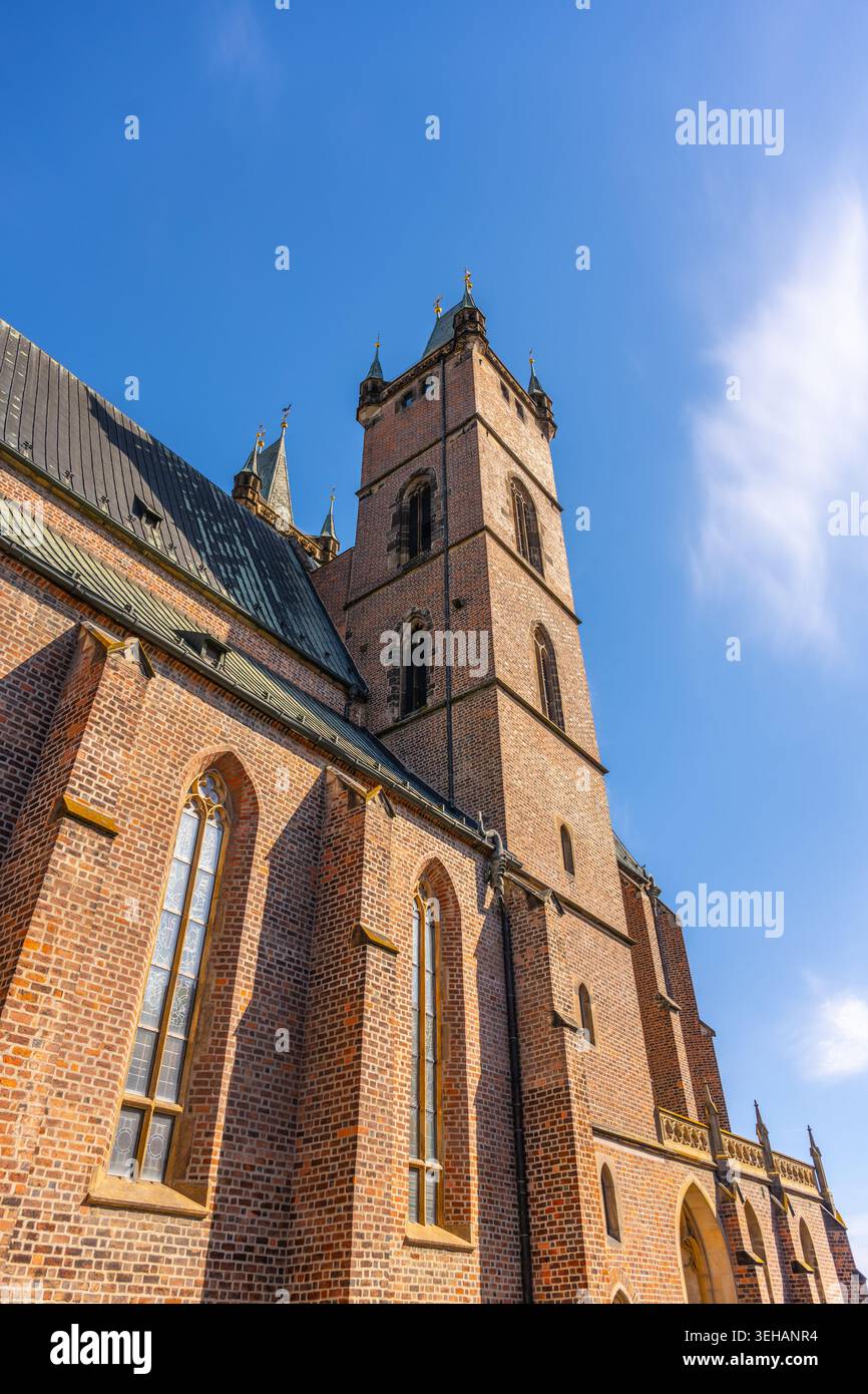 Die Kathedrale des Heiligen Geistes in Hradec Kralove steht hoch vor einem klaren blauen Himmel. Die historische Backsteinstruktur verfügt über detaillierte Fenster und einen Stockfoto