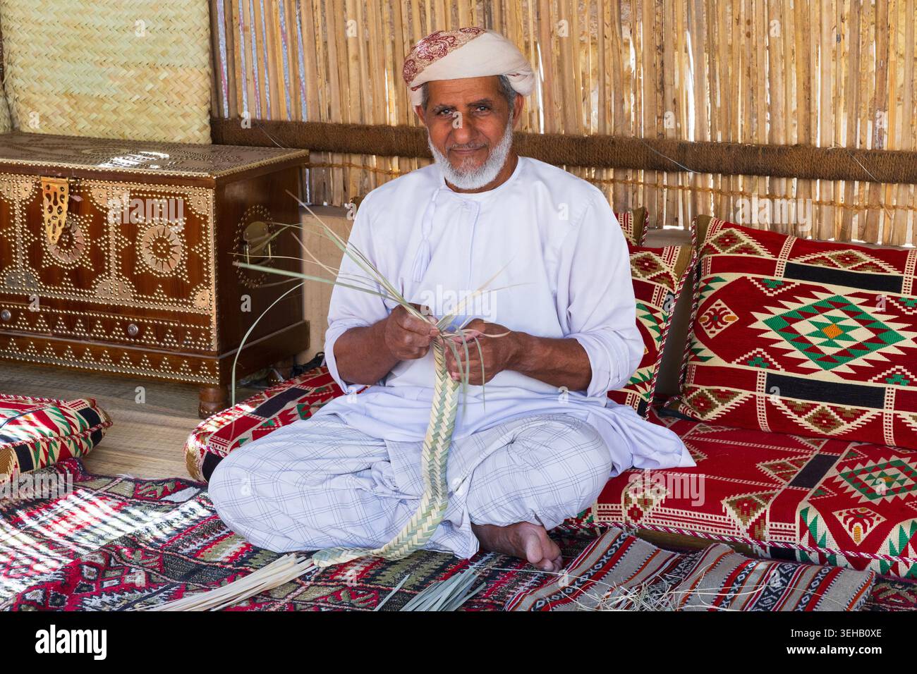 Ein omanischer Korbweber (Handwerker) bei der Arbeit im Nizwa Fort aus dem 17. Jahrhundert in Nizwa, Oman Stockfoto