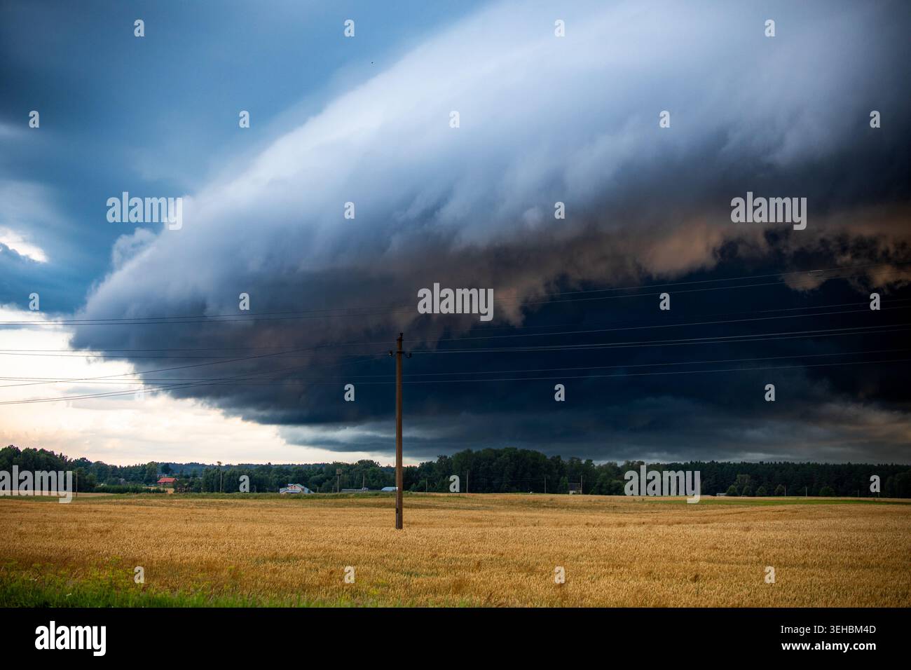 Dramatische Superzellsturmwolke, die sich über ländliches Ackerland mit dunklen Schelfwolken und bedrohlichem Sommerwetter in Litauen bewegt. Stockfoto