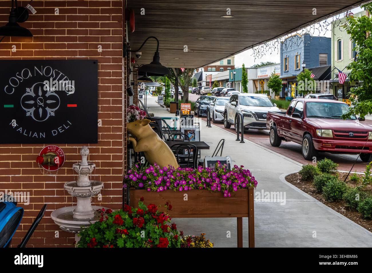 Cosa Nostra Italian Deli mit einer goldenen Schweineskulptur, die im Fenster des Restaurants auf der West Montrose Street im historischen Stadtzentrum von Clermont, FL, blickt. Stockfoto