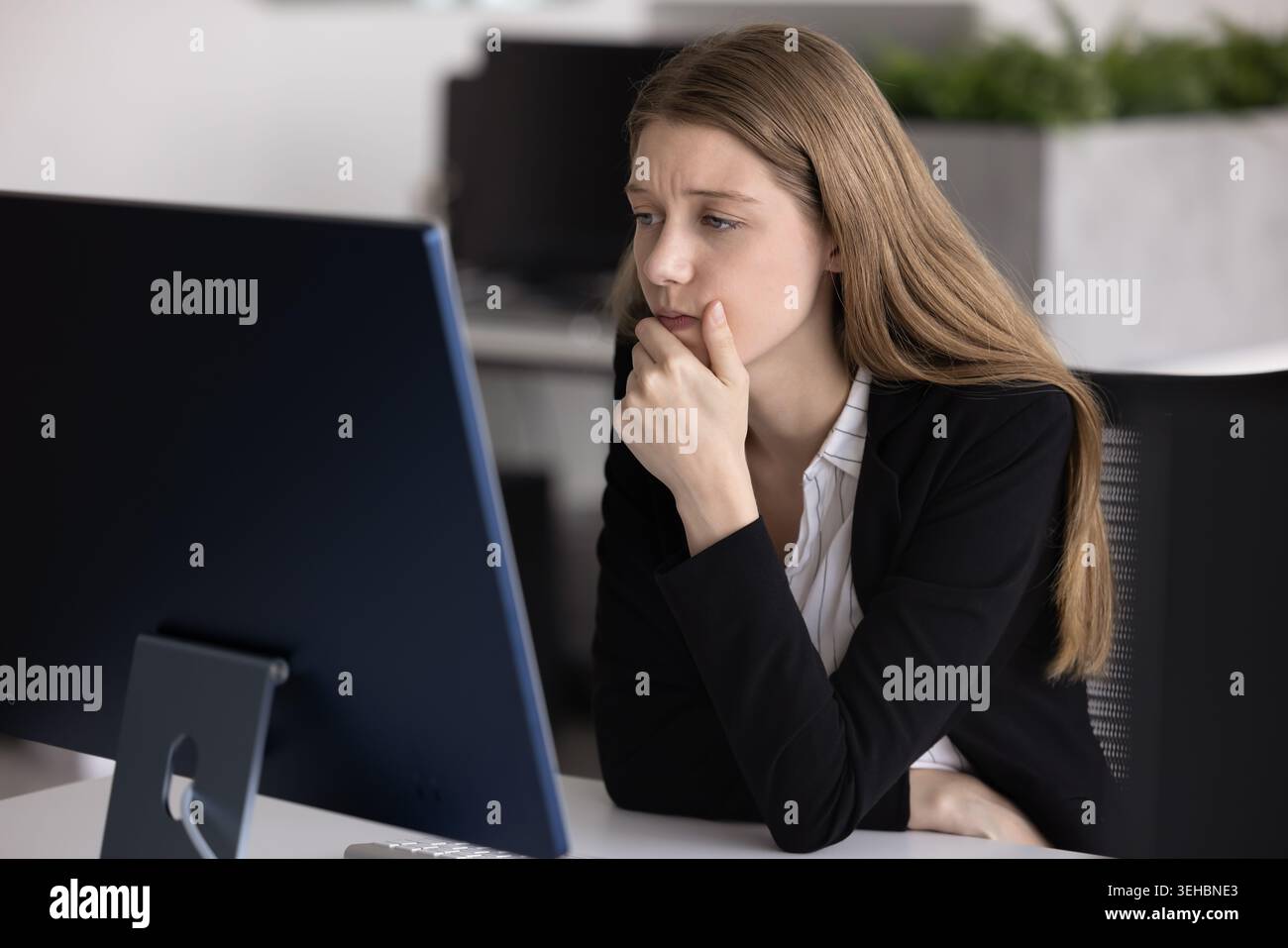 Frau starrt mit besorgtem Ausdruck auf den Computer Stockfoto