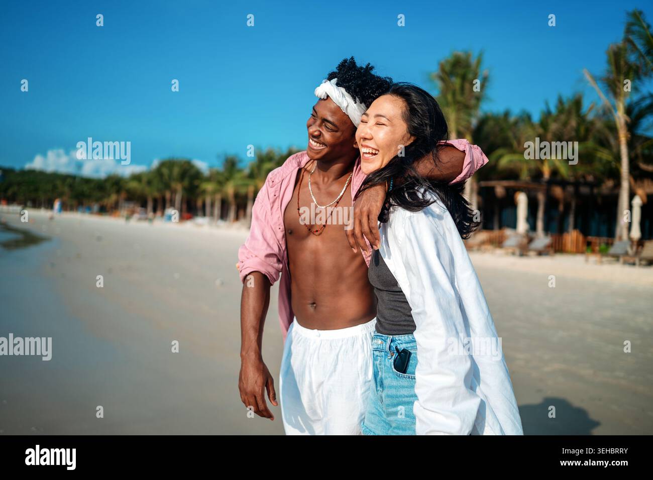 Reines Glück. Ein junges, vielseitiges, multiethnisches Paar genießt jeden Moment ihres tropischen Urlaubs Stockfoto