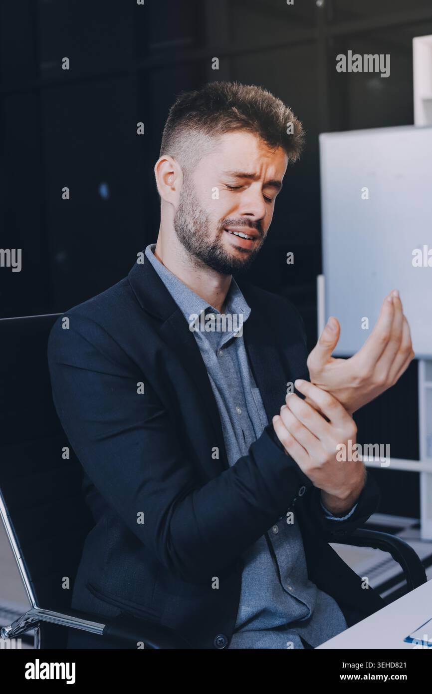 Ein Mann mit Halsschmerzen arbeitet im Büro, ein Geschäftsmann bei der Arbeit hat Halsschmerzen Grippe und Erkältung, benutzt ein Notebook bei der Arbeit. Stockfoto