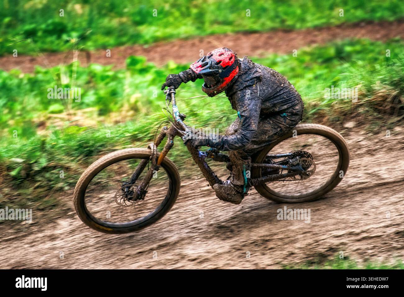 Downhill-Mountainbiker fahren auf matschigen Strecken in nassem Gelände mit hoher Geschwindigkeit, Adrenalin und extremer Outdoor-Sportatmosphäre. Stockfoto