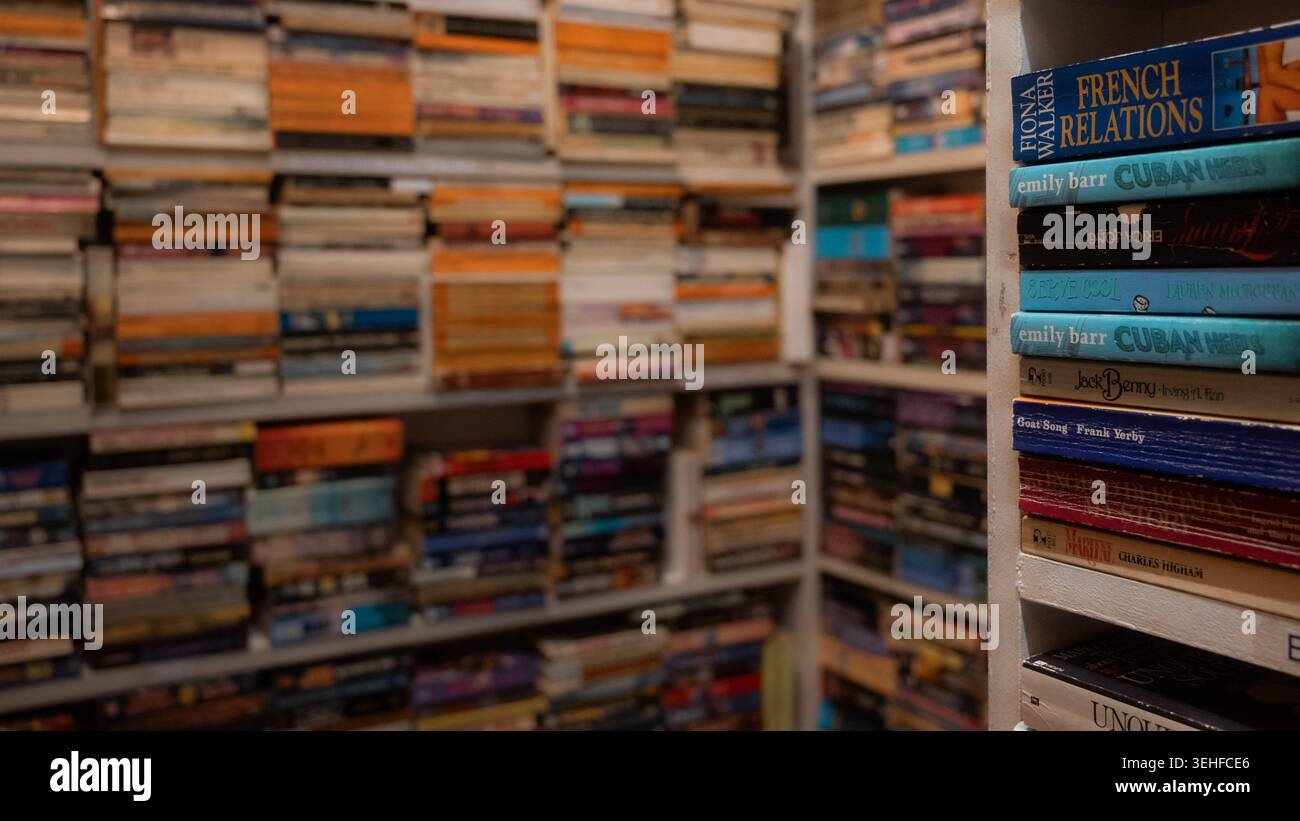 Raumhohe Regale mit bunten Büchern aus gebrauchter Hand in einem engen Pariser Bücherladen, Paris, Frankreich, Frühjahr 2026, Editorial. Stockfoto