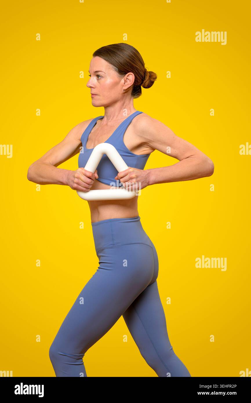 Eine sportliche Frau mit einer Dreieck-Hantel Stockfoto