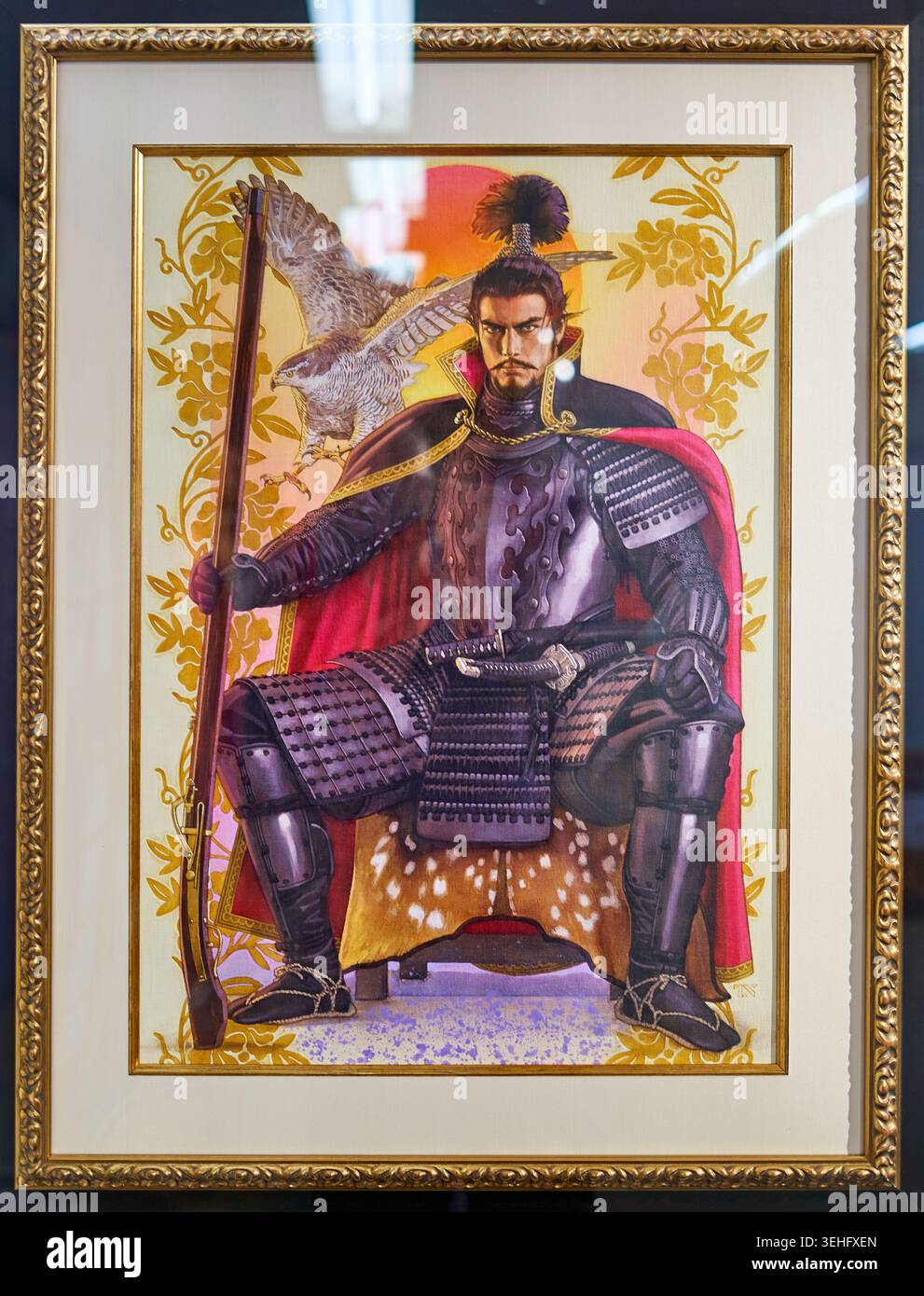 Ein gerahmtes Gemälde zeigt einen japanischen Samurai-Krieger in voller traditioneller Rüstung, der auf einem mit geflecktem Hirschleder bezogenen Hocker sitzt. Die Figur trägt ein Stockfoto