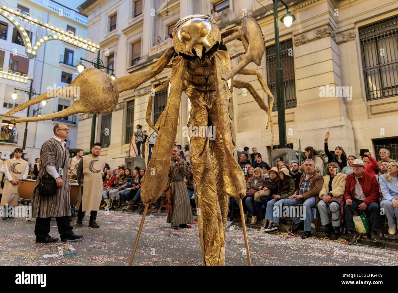 Ein Künstler in einem riesigen goldenen Skorpion-Anzug tritt beim Aufstieg des Antares Ballet bei der Alcoy Festival Parade am 25. April 2026 in Spanien auf Stockfoto