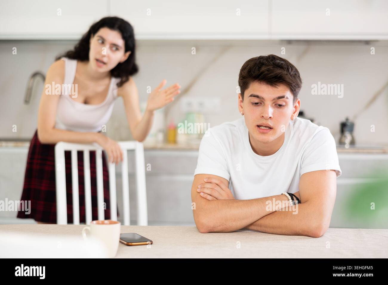 Die junge Frau streitet mit dem jungen Mann in der Küche Stockfoto