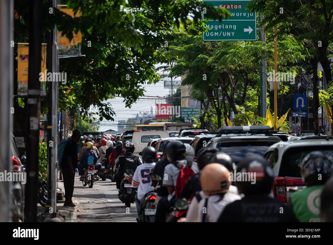 YOGYAKARTA, INDONESIEN – Motorräder und Fahrzeuge bewegen sich langsam durch den starken Verkehr auf einer Hauptstraße in Yogyakarta. Wegweiser Richtung Krat Stockfoto