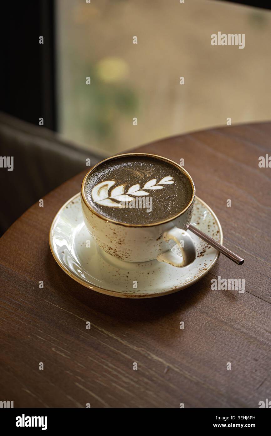 Hojicha Latte mit Latte Art auf dem Tisch Stockfoto