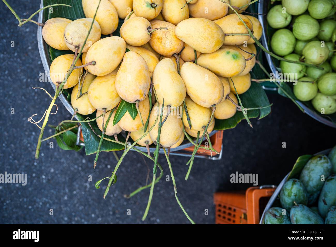 Korb gefüllt mit frischen rohen thailändischen Mangobrüchten, die am Street Food Market in Thailand verkauft werden. Stockfoto