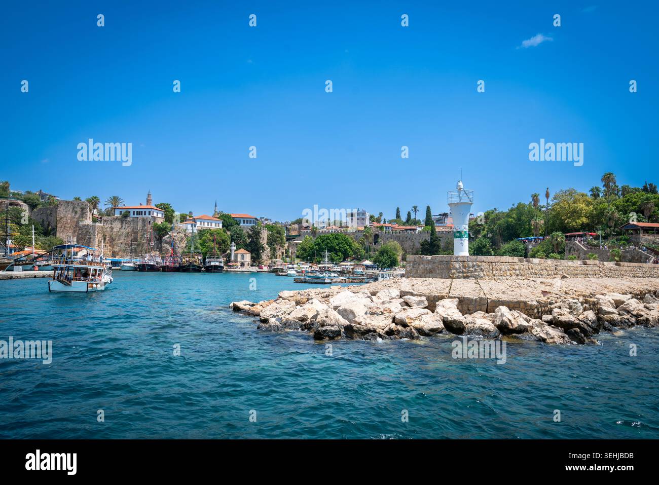 Malerischer alter Hafen von Antalya mit Blick auf den Leuchtturm und das Taurusgebirge auf das Mittelmeer, Türkei Stockfoto