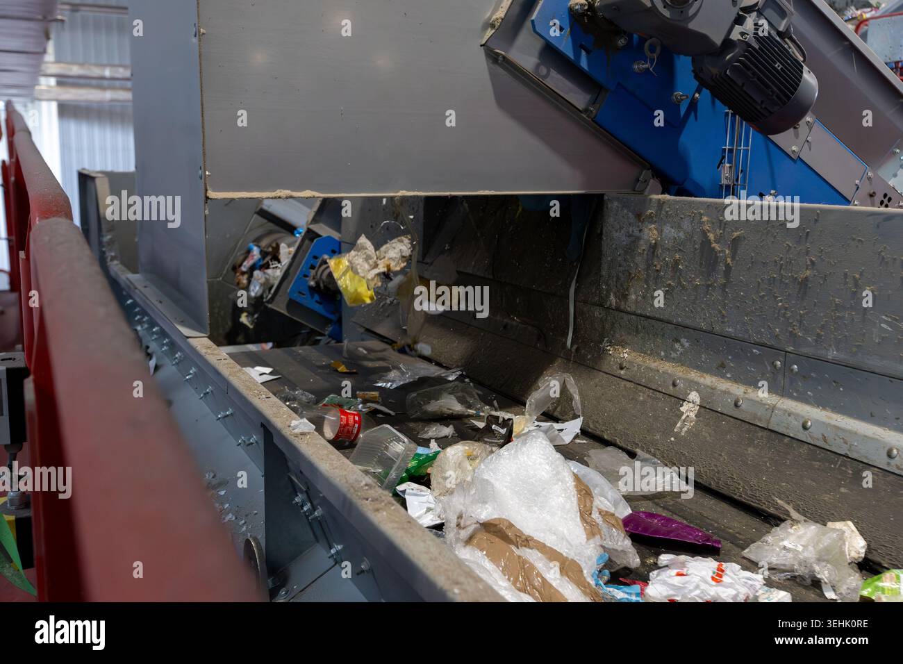 Gemischte Siedlungsabfälle einschließlich Kunststoffverpackungen, Folien, Behältern und Ablagerungen, die auf Förderband transportiert werden. Industrielle Sortiergeräte Stockfoto