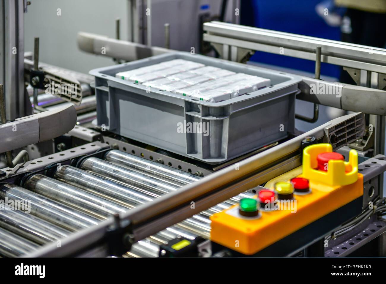 Automatisiertes Rollenfördersystem, das Kunststoffkiste mit Produkten in der Fabrik, industrielle Automatisierungslogistik transportiert. Stockfoto