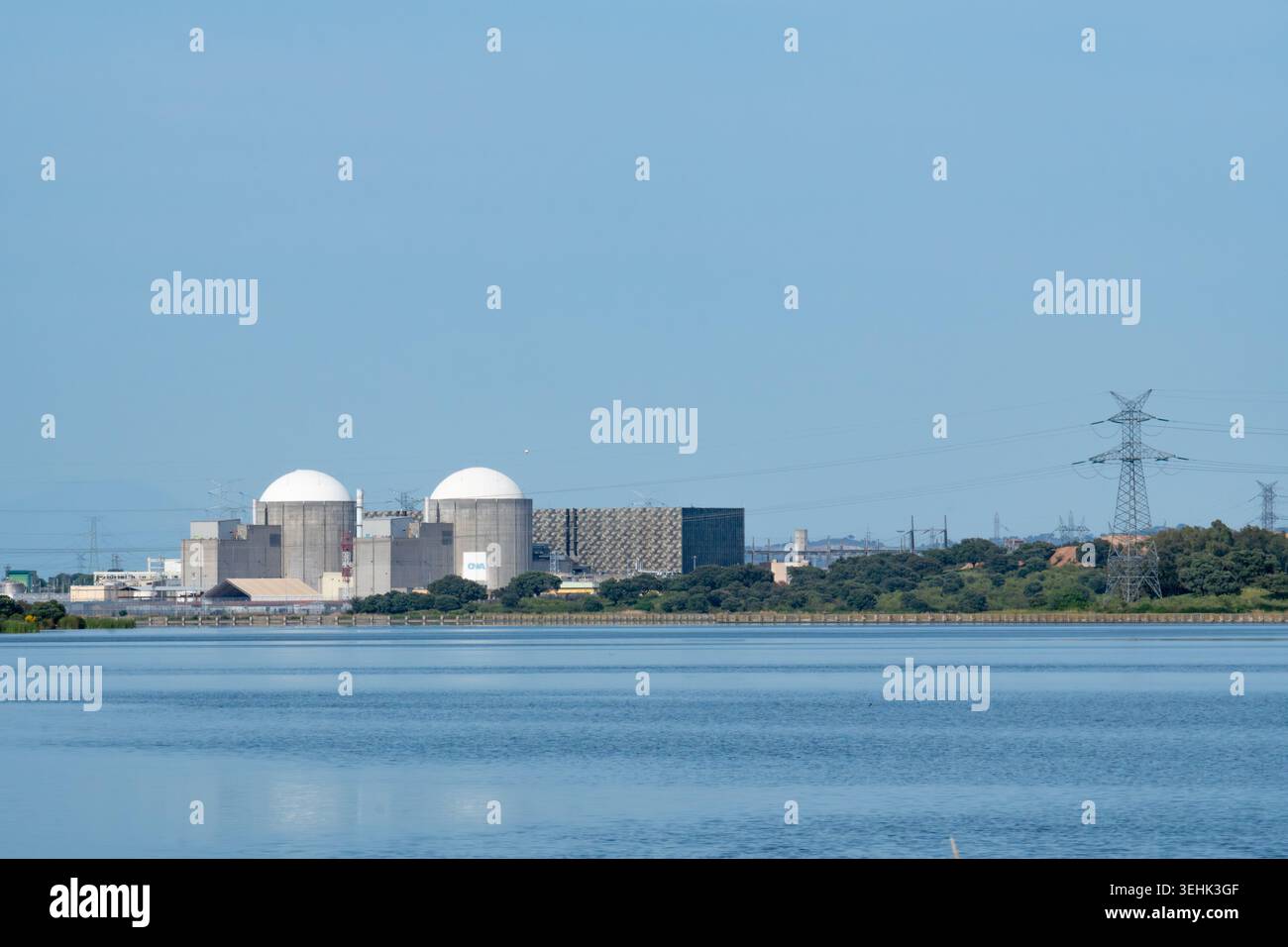 Almaraz, Caceres, Spanien - 19. April 2026: Almaraz Kernkraftwerk mit seinen massiven Eindämmungskuppeln, die sich im angrenzenden Wasser spiegeln, was hervorhebt Stockfoto