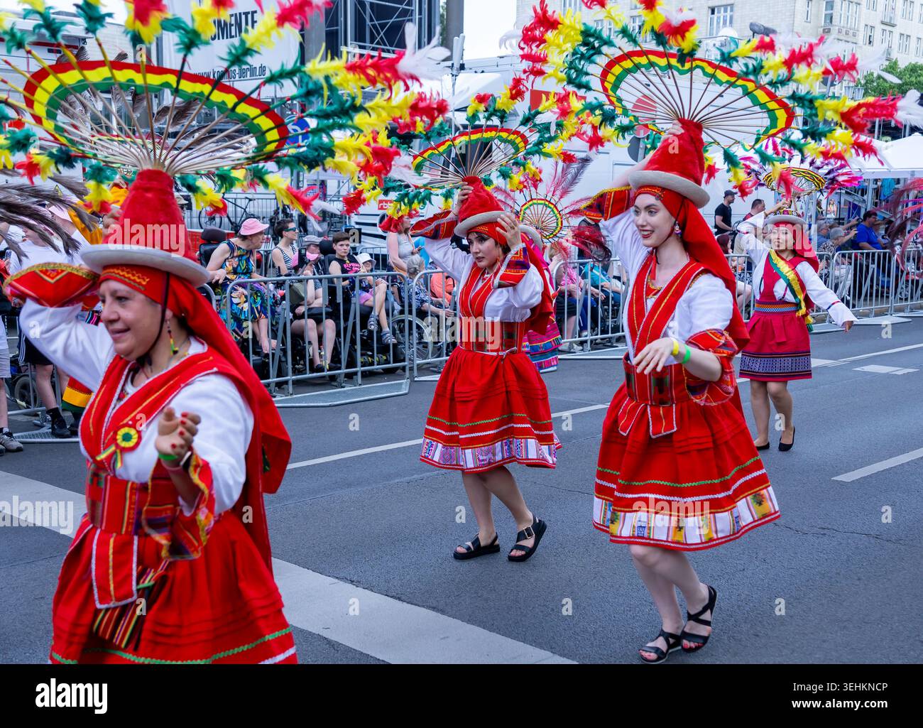 Berlin, Deutschland - 24. Mai 2026: Anden-Folklore-inspirierte Künstler mit Federkopfschmuck tanzen während der Straßenparade des Karnevals der Kulturen. Stockfoto