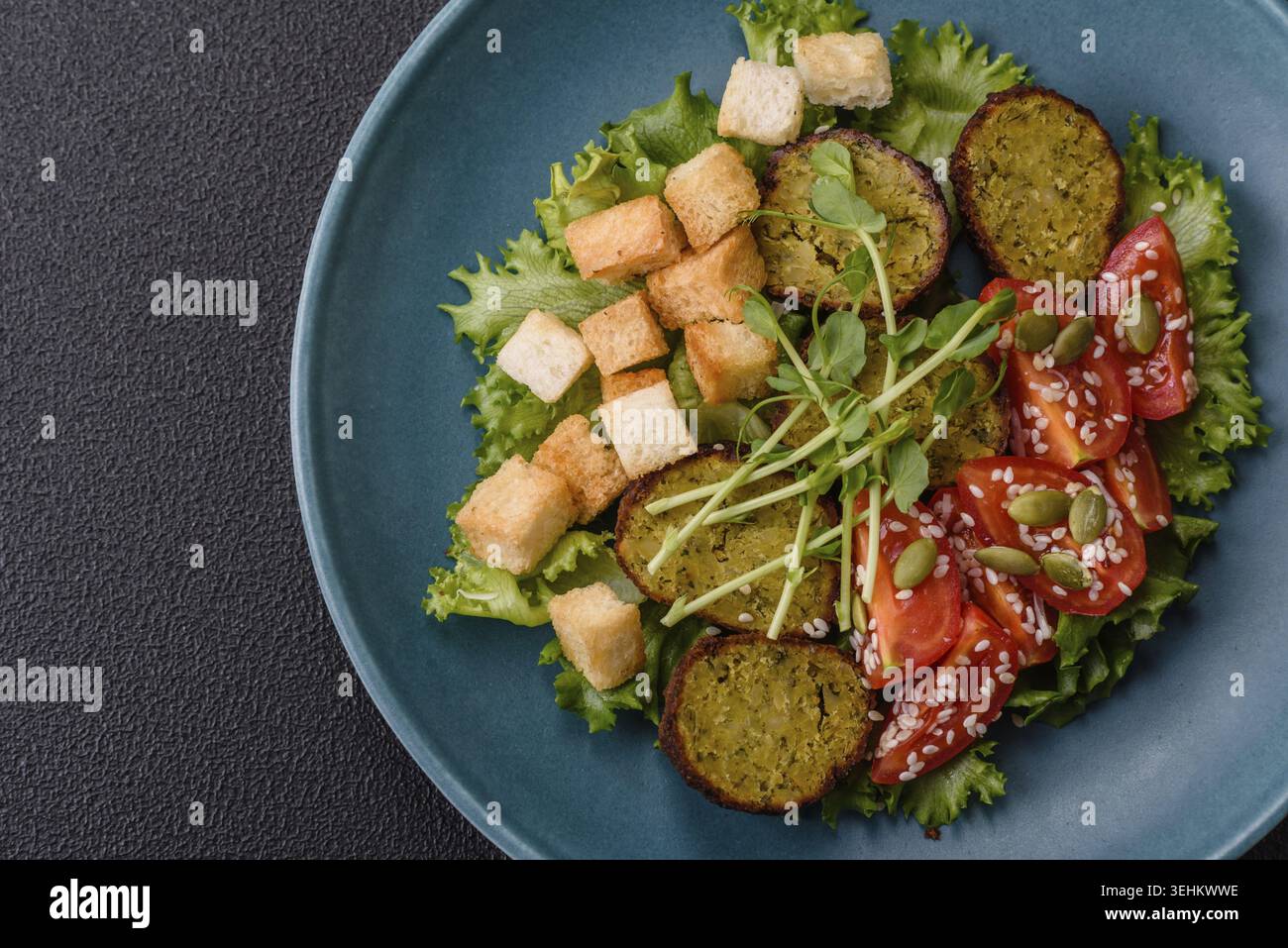 Essen, deftige köstliche frittierte Falafel aus Kichererbsen, Kümmel, Hummus mit Salz und Gewürzen auf dunklem Betonhintergrund Stockfoto