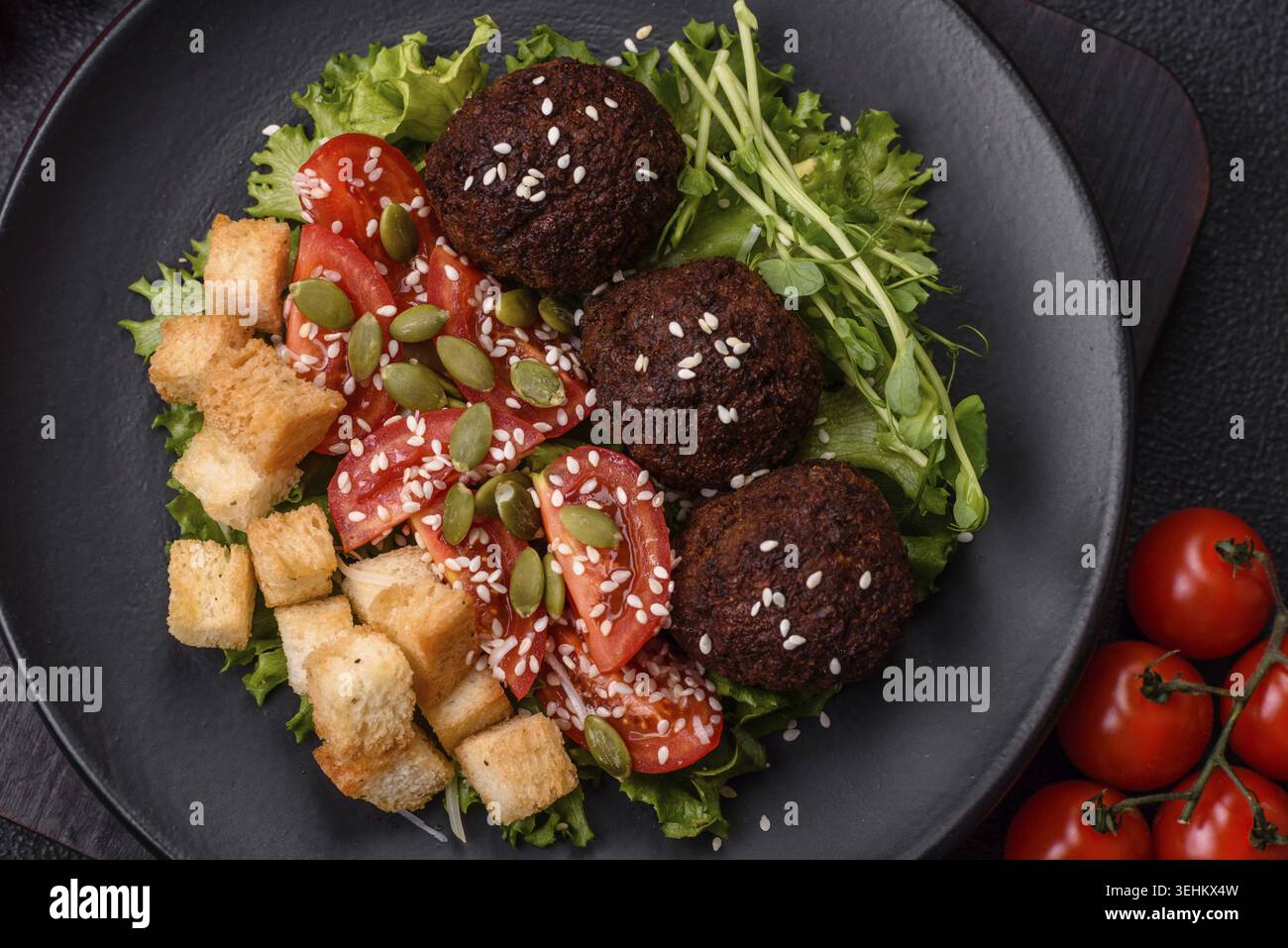 Essen, deftige köstliche frittierte Falafel aus Kichererbsen, Kümmel, Hummus mit Salz und Gewürzen auf dunklem Betonhintergrund Stockfoto