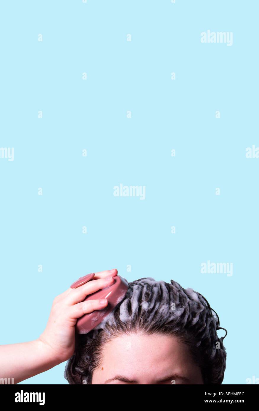Haarbürste zur Stimulation des Haarwuchses auf blauem Hintergrund. Mikrozirkulation, hilft, natürliche Öle gleichmäßig über die Kopfhaut zu verteilen Stockfoto