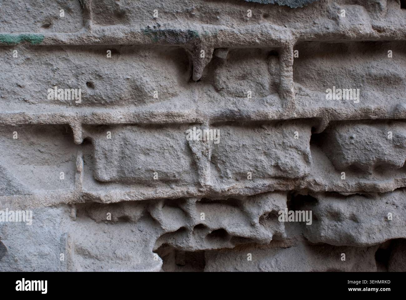 Digitale Nahaufnahme alternder grauer Ziegelsteine an einer alten Gebäudewand mit rauem Mörtel, verwitterter Beschichtung, Verfall und strukturierter architektonischer Oberfläche Stockfoto