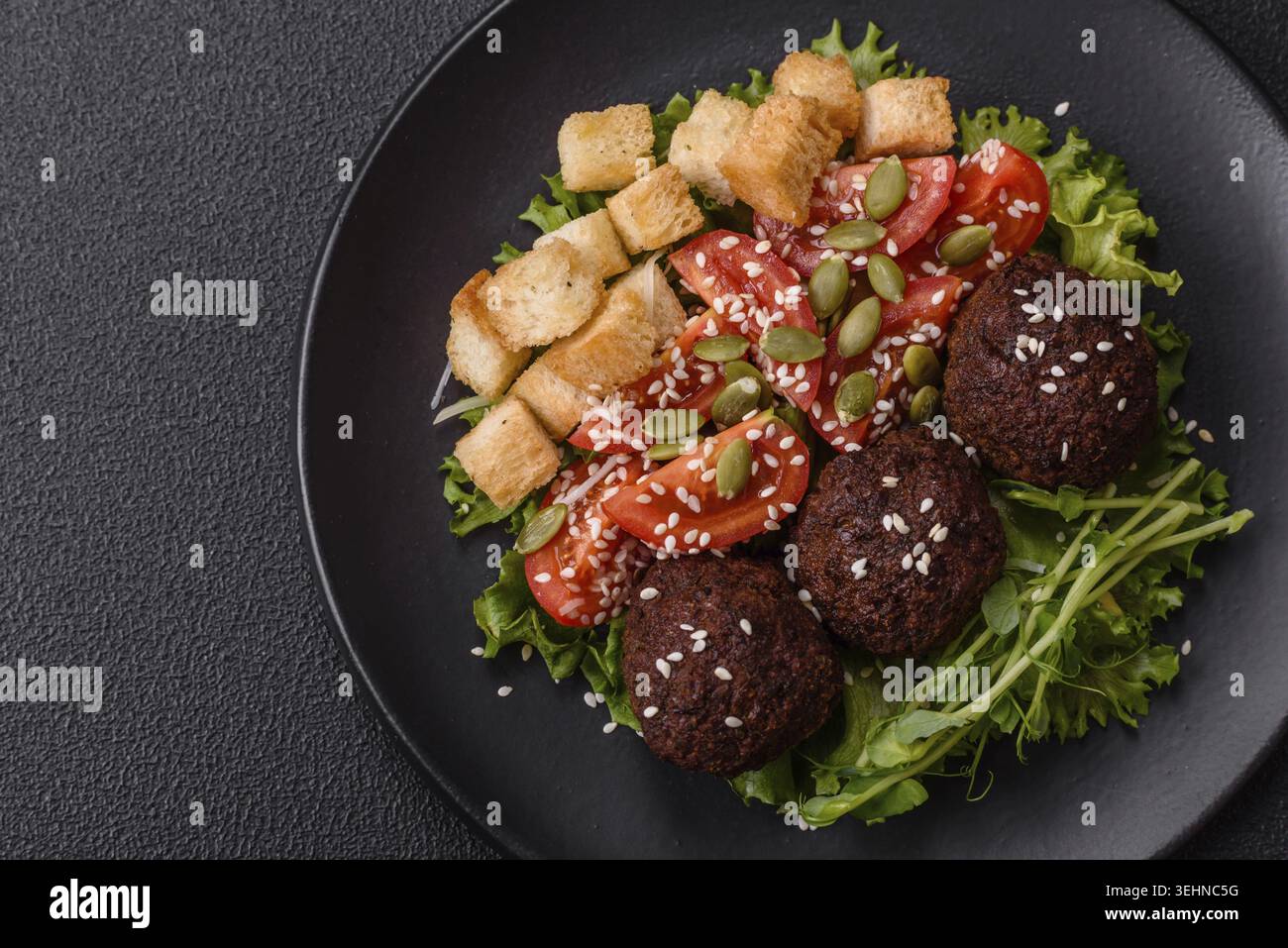 Essen, deftige köstliche frittierte Falafel aus Kichererbsen, Kümmel, Hummus mit Salz und Gewürzen auf dunklem Betonhintergrund Stockfoto