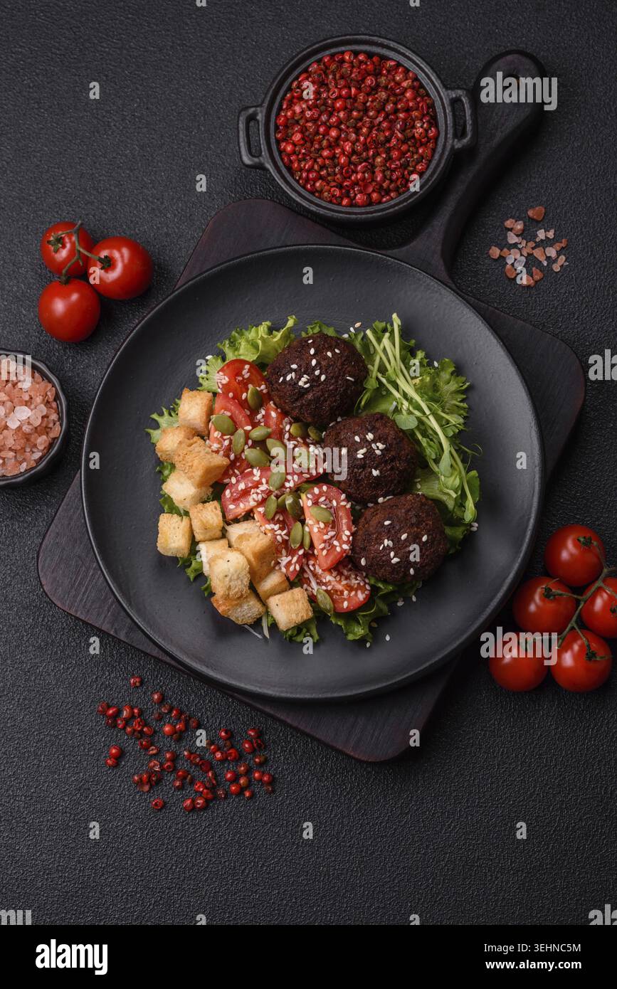 Essen, deftige köstliche frittierte Falafel aus Kichererbsen, Kümmel, Hummus mit Salz und Gewürzen auf dunklem Betonhintergrund Stockfoto